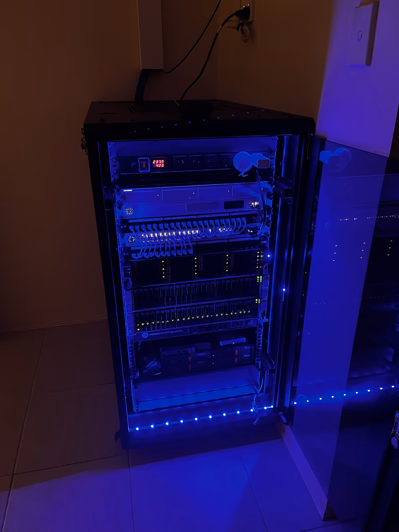 Front view of a rack cabinet with blue LED lighting and its door open.